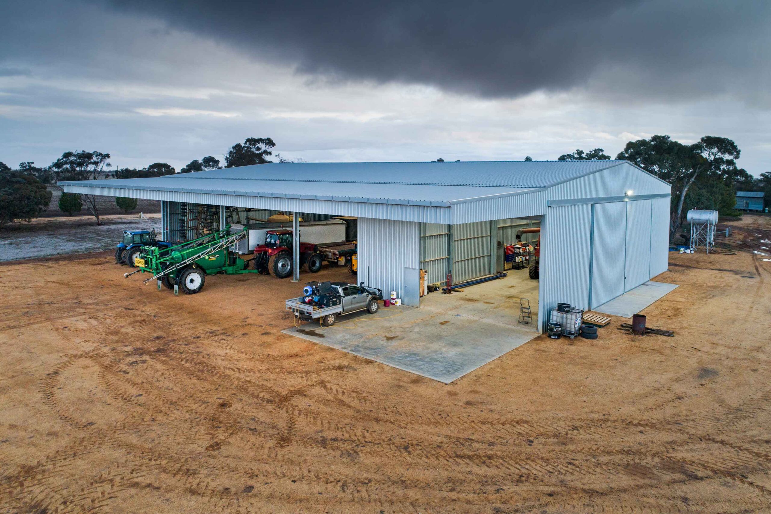 Farm machinery storage shed and workshop for farm maintenance with canopy and sliding door. Design and build by Entegra
